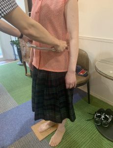 脚長差の数値を専用器具で測定し、コルクシートで足元の高さバランスを確認している様子